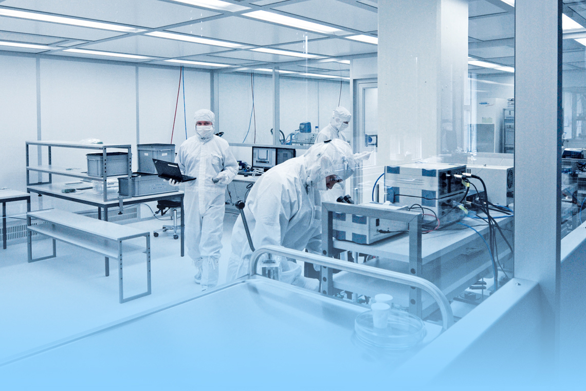 Professionals working in a lab wearing PPE