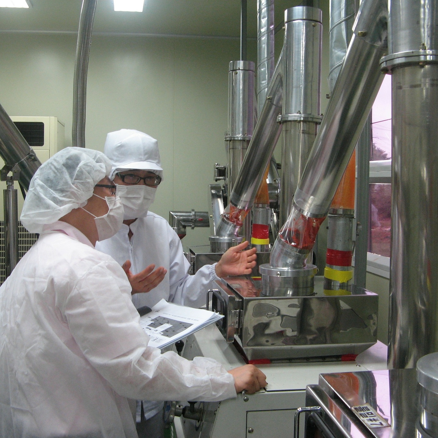 Two workers with clipboard in food lab