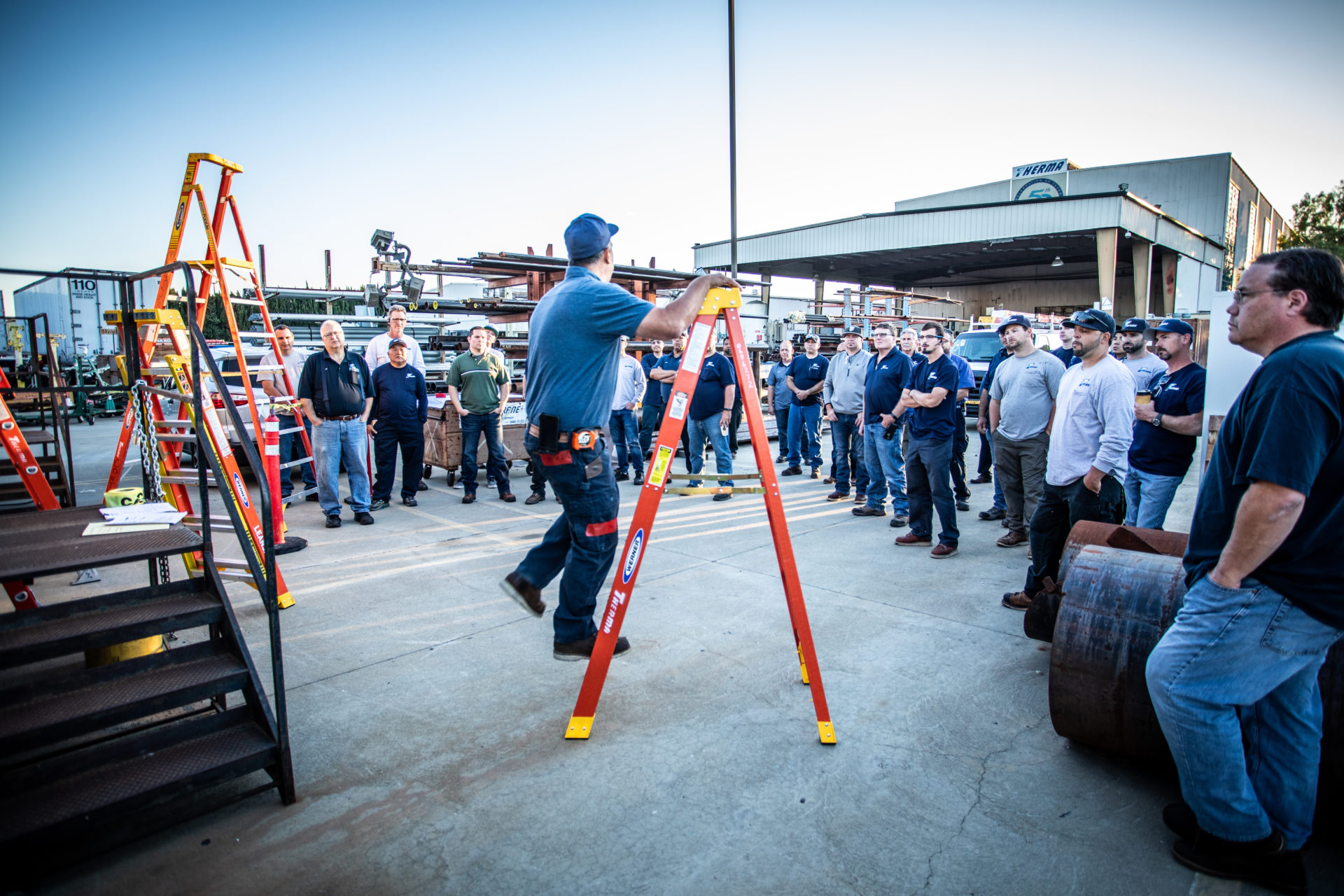 Crowd watching man demonstrate how to use ladders safely